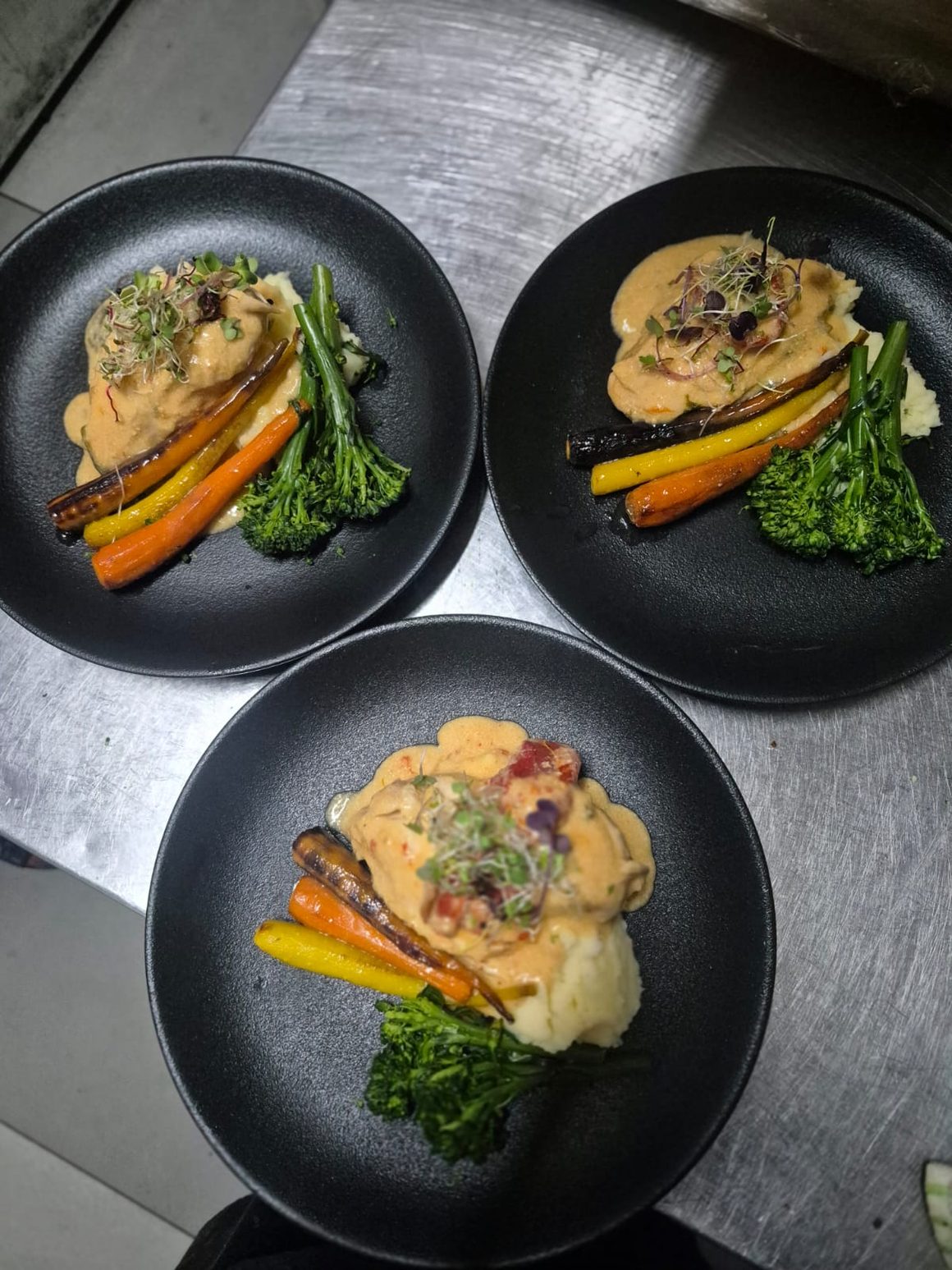Plated main courses prepared for a corporate event