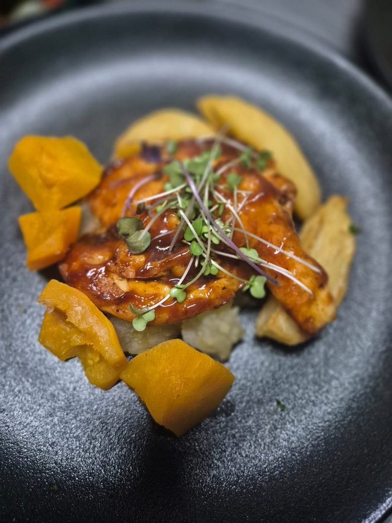 A glazed chicken main with roast butternut, plated by King Protea Services